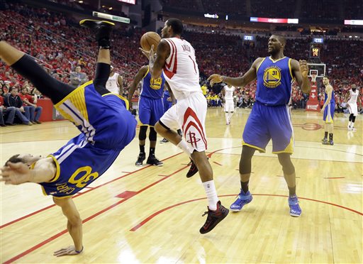 Golden State Warriors guard Stephen Curry (30) topples over Houston Rockets forward Trevor Ariza (1) during the first half in Game 4 of the Wes_167489