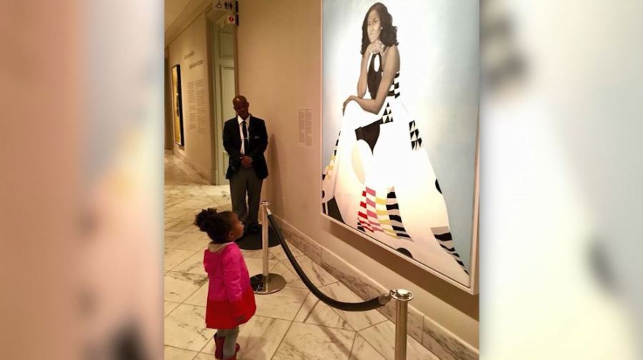 Young girl stands awestruck in front of Michelle Obama portrait